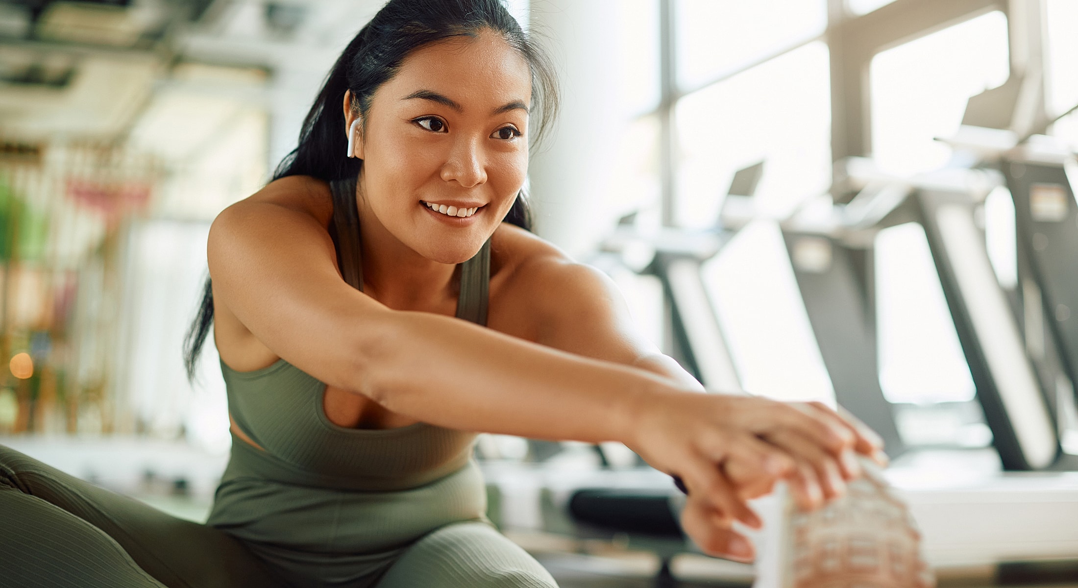 Woman stretching in a gym setting.